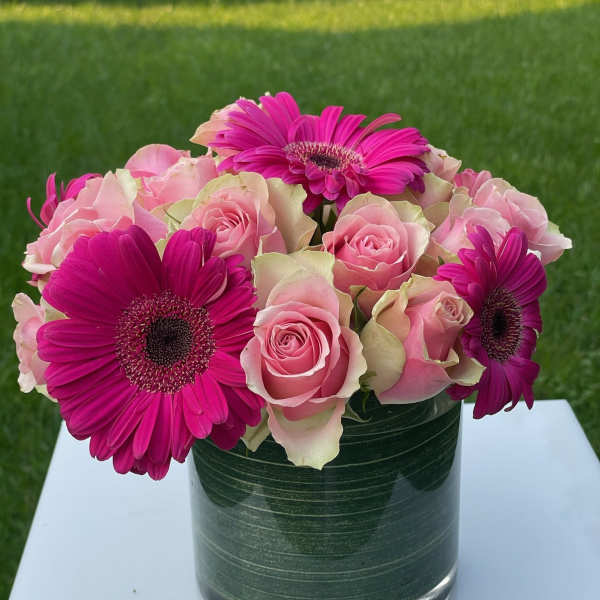 Pink roses and magenta gerbera daisies in a glass vase