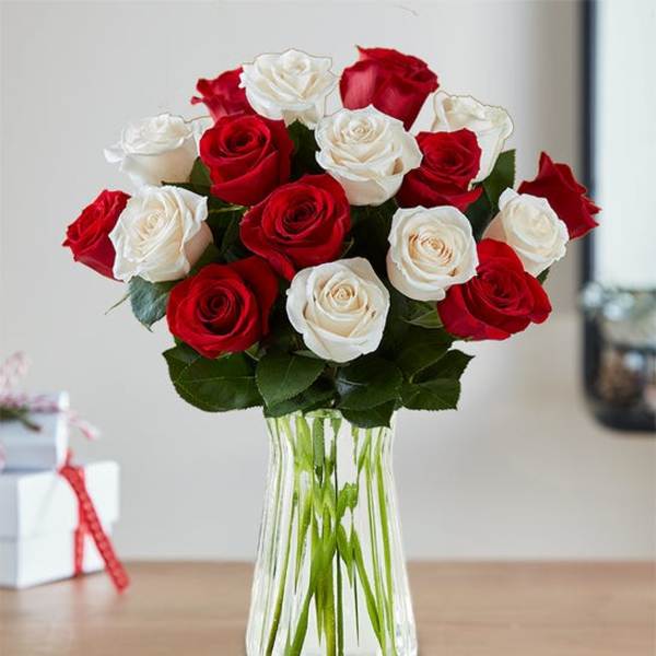 Red and white roses arranged in a clear glass vase