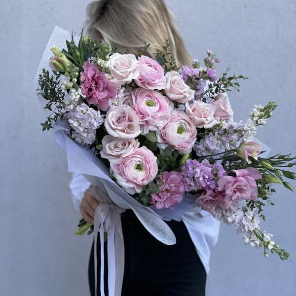 Woman holding a large bouquet of pink and white flowers