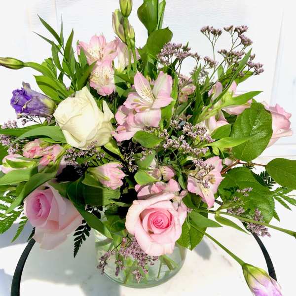 Pink and white roses with alstroemeria in a glass vase