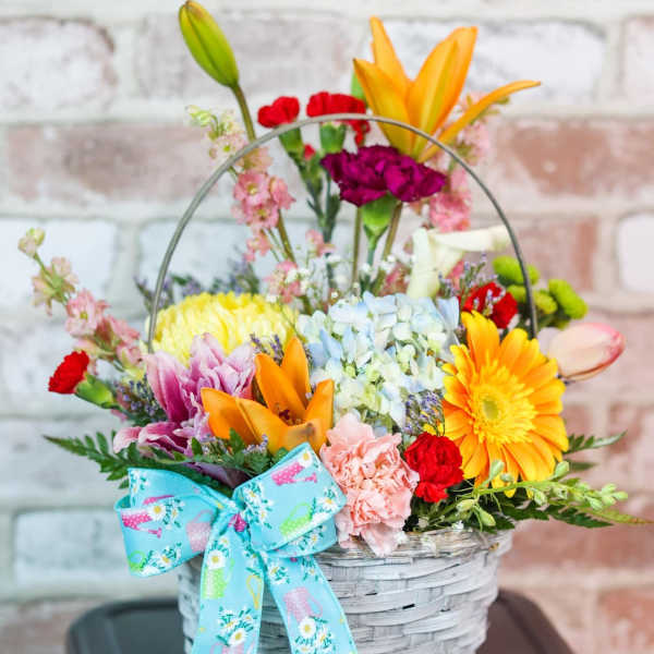 Colorful mixed flower basket with a blue bow