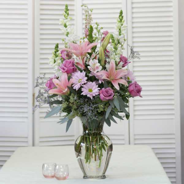 Pink lilies and roses in a clear glass vase