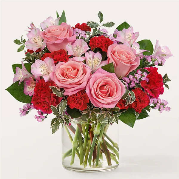 Pink roses and red carnations in a clear glass vase