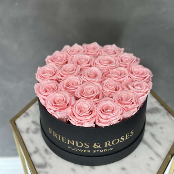Pink roses arranged in a round black box