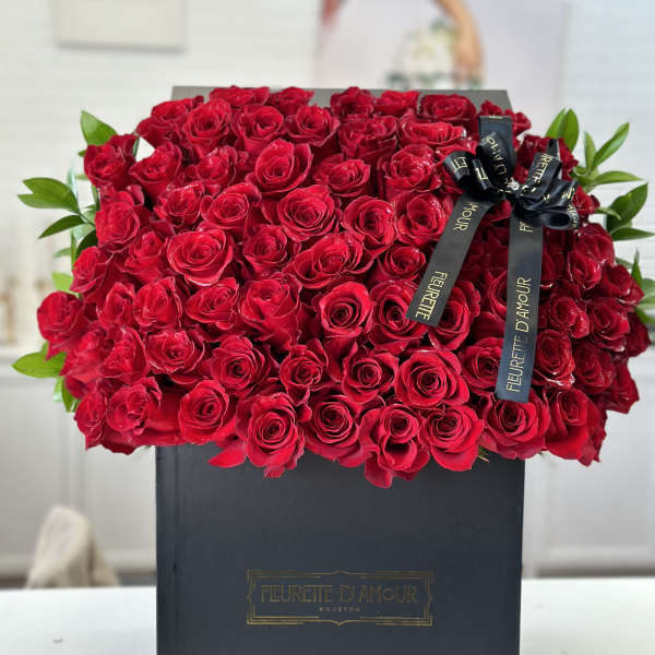 Large box of red roses with a black ribbon bow