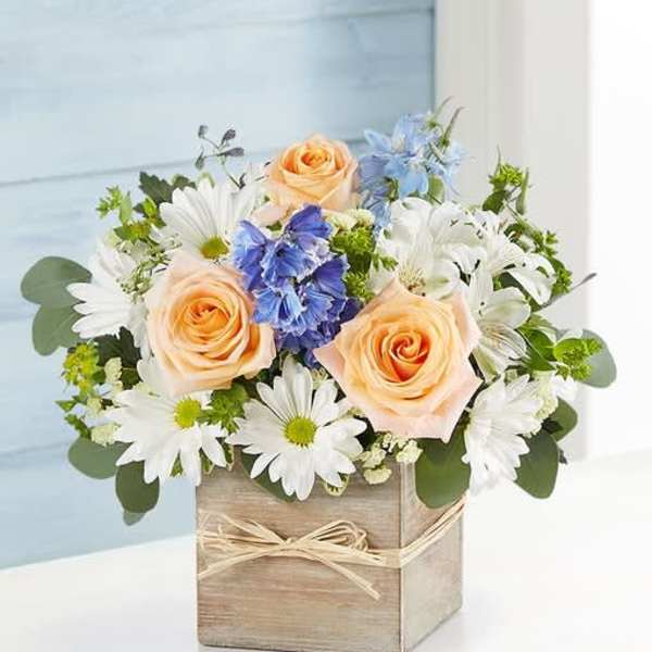 Peach roses and white daisies in a wooden box