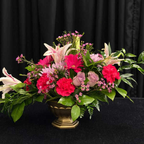 Pink and white floral arrangement in a gold vase
