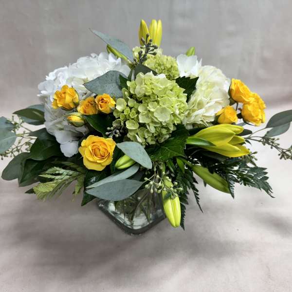 Yellow roses and white hydrangeas in a glass vase