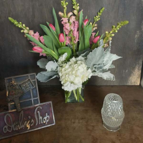 Pink tulips and white hydrangea in a clear glass vase