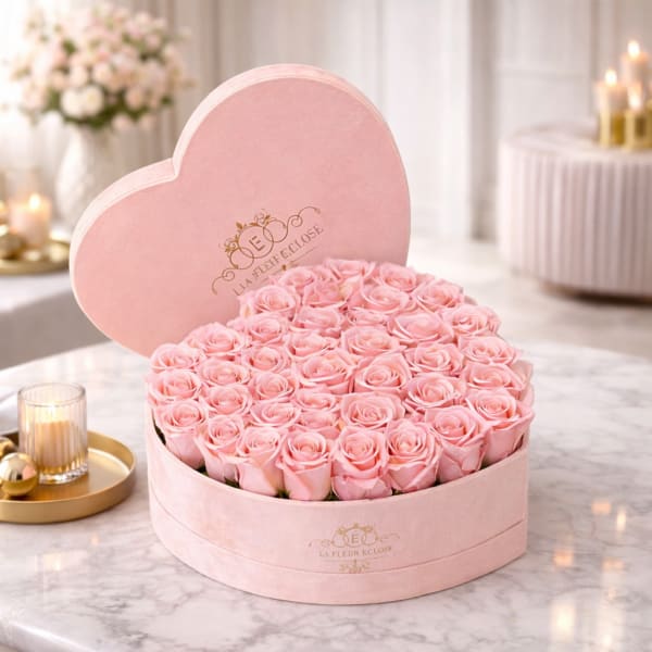 Pink roses arranged in a heart-shaped pink box