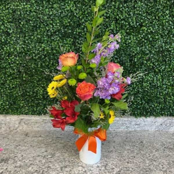 Mixed bouquet in a white vase with an orange ribbon