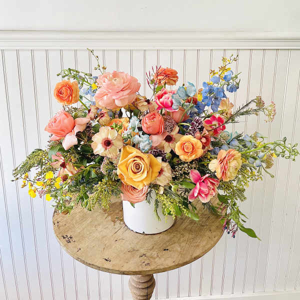 Colorful mixed flower arrangement in a white container