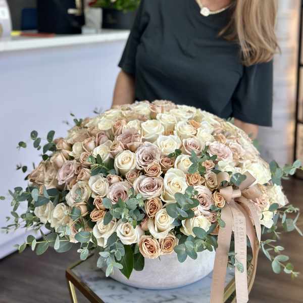 Large dome bouquet of cream and blush roses in a round vase