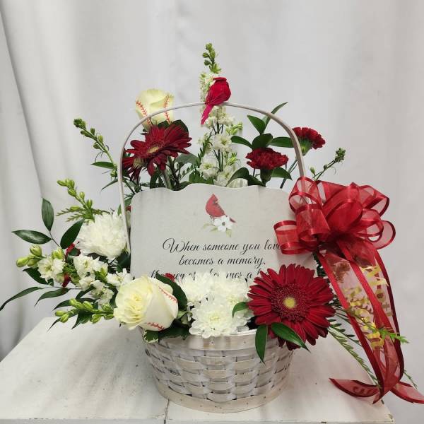 Basket arrangement with red and white flowers and a memorial card