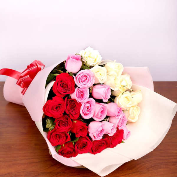 Bouquet of red, pink, and white roses wrapped in pale paper