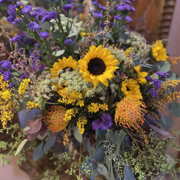Bouquet with sunflowers, purple blooms, and yellow filler flowers
