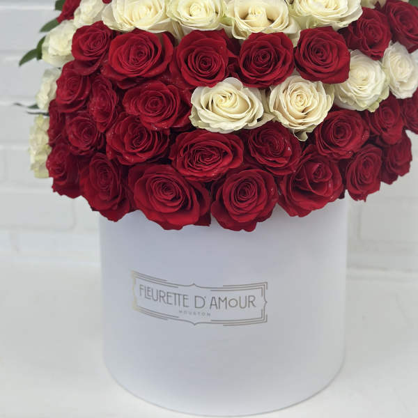 Red and white roses arranged in a white hat box