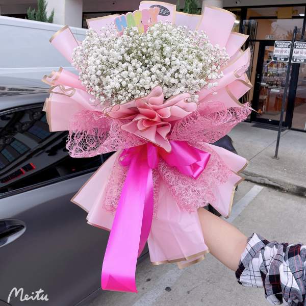 Large pink bouquet of white baby's breath with ribbon wrapping