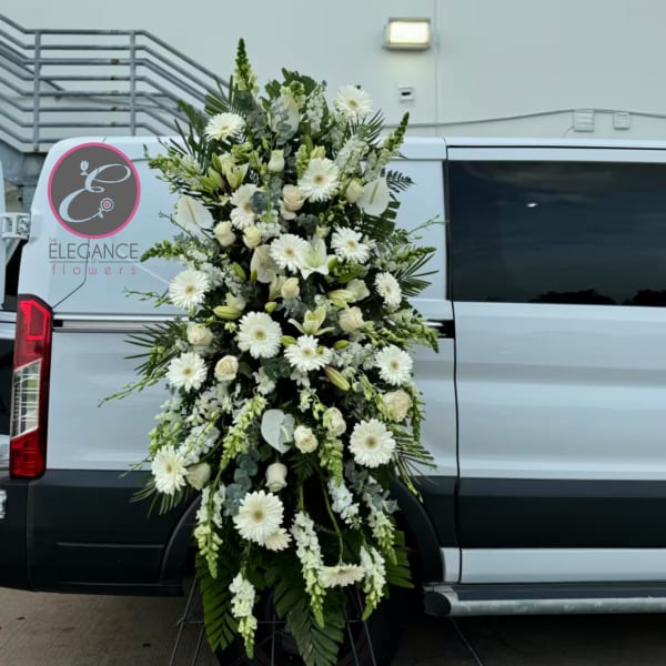 Tall white floral spray arranged on the side of a white van