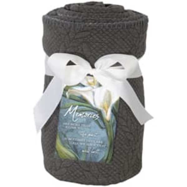 Dark woven gift basket tied with a white ribbon and a floral label