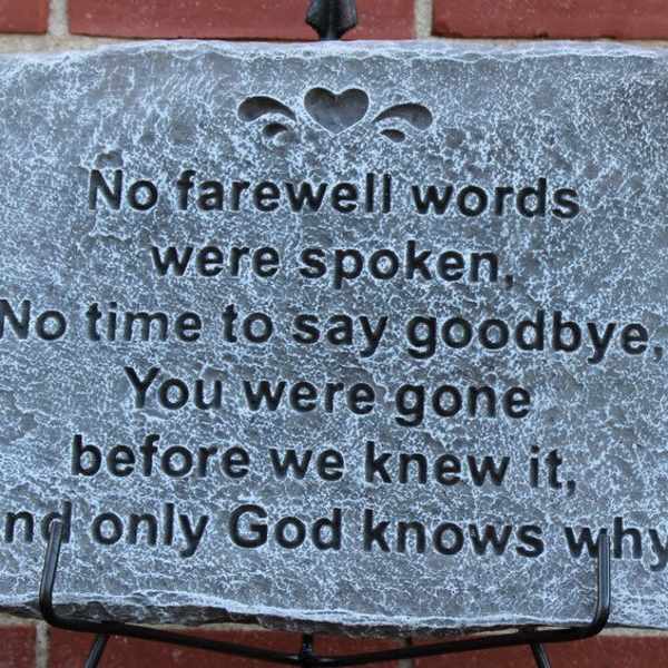 Memorial stone plaque with engraved sympathy verse on a stand