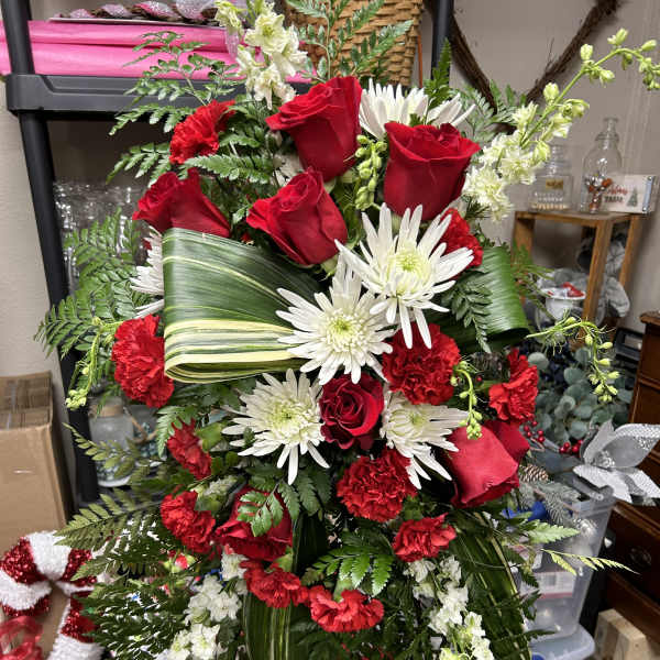 Red roses and white daisies arranged in a standing spray
