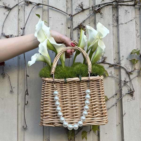 Wicker basket with white calla lilies and pearl handles