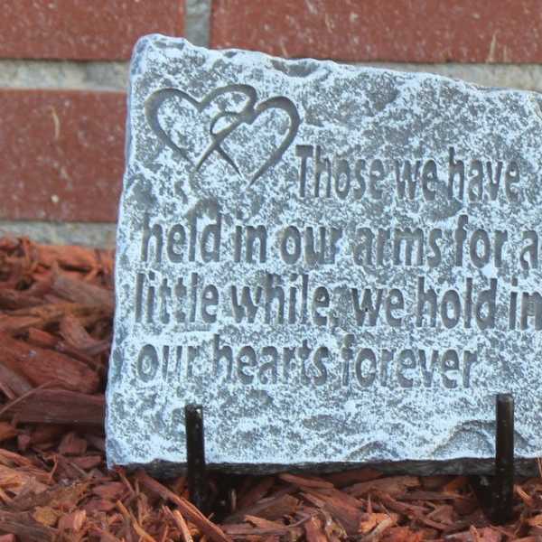 Decorative stone plaque with a heart design and engraved memorial quote
