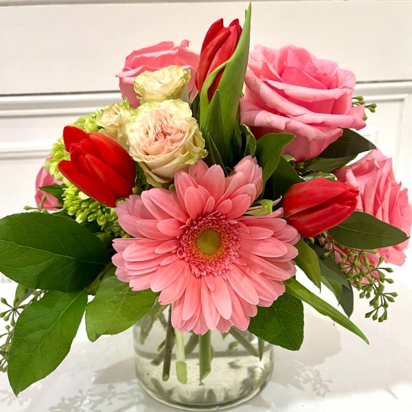 Pink and red mixed bouquet in a clear glass vase