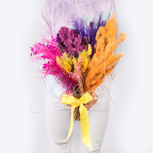 Bright dried bouquet with pink, purple, yellow, and orange stems tied with a yellow ribbon