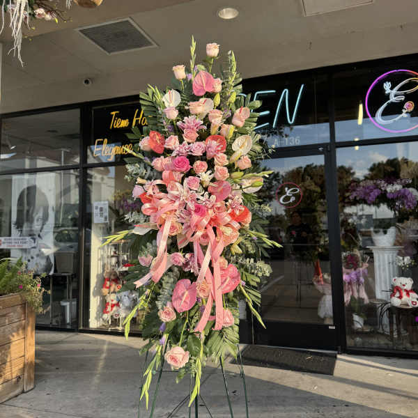 Tall pink floral standing arrangement on a metal easel