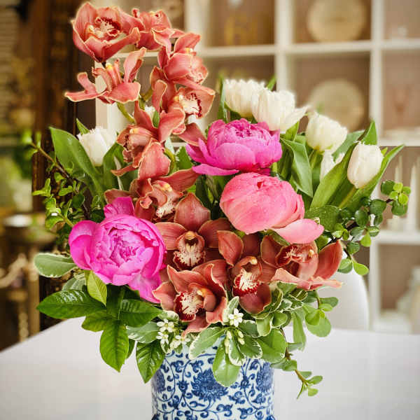 Pink peonies and orchids in a blue-and-white ceramic vase
