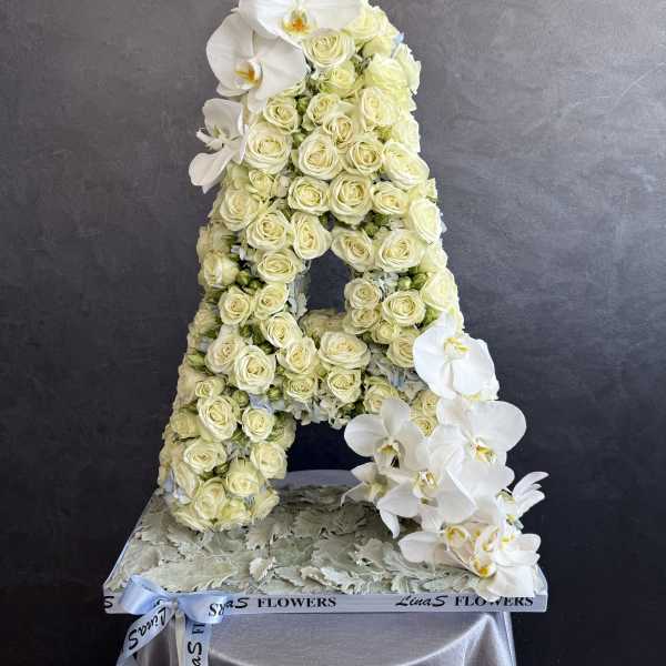White rose and orchid floral arrangement shaped like the letter A