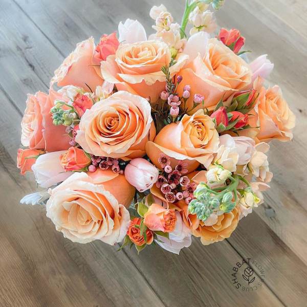 Bouquet of peach roses with small pink and white accent flowers
