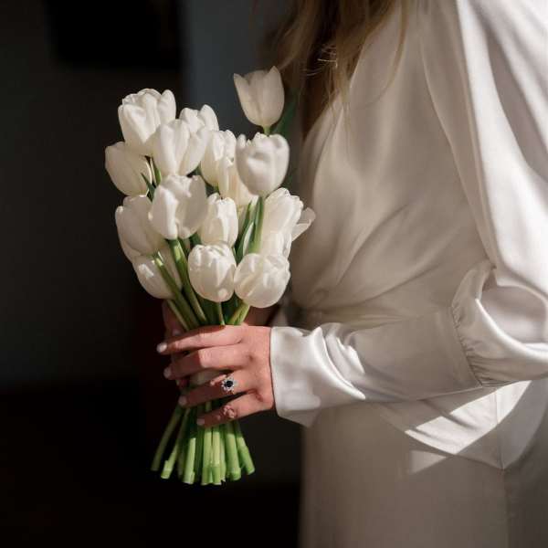 Woman holding a bouquet of white tulips