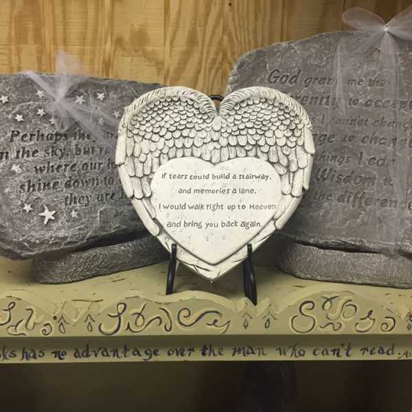 Heart-shaped memorial plaque with angel wings on a stand