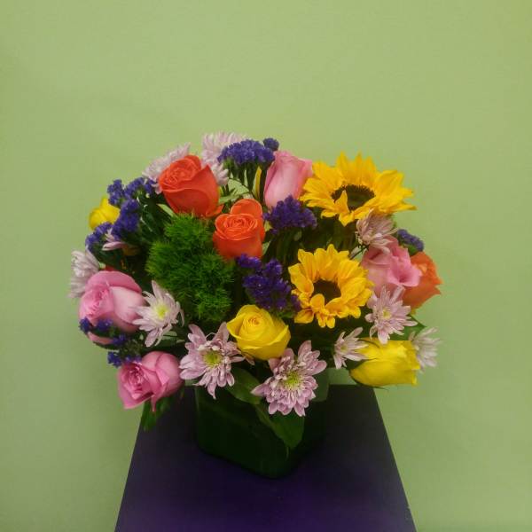 Mixed bouquet of roses, sunflowers, and small purple daisies