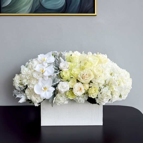 White floral arrangement in a textured rectangular box