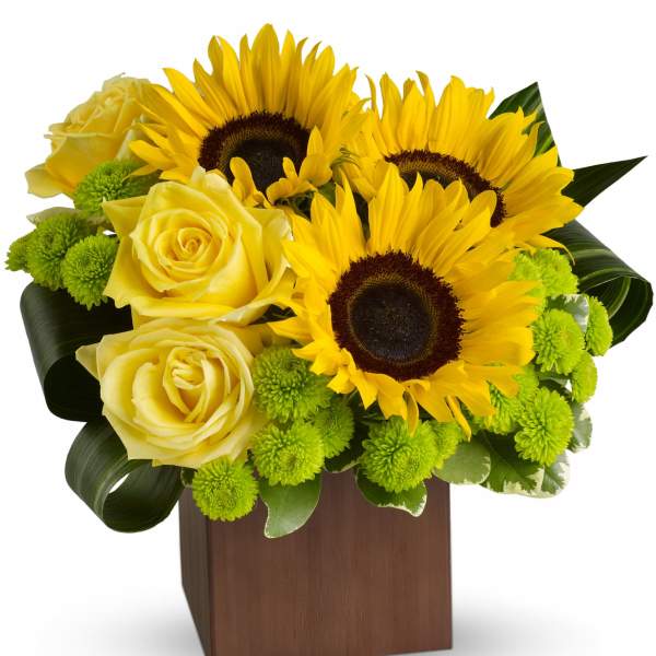 Yellow roses and sunflowers in a wooden cube vase