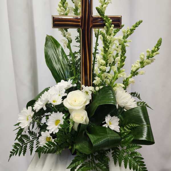 White floral arrangement with a wooden cross centerpiece