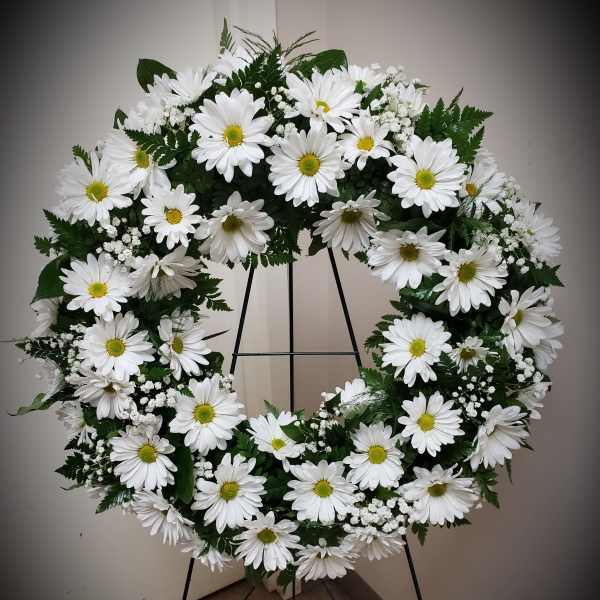 White daisy wreath on a black stand