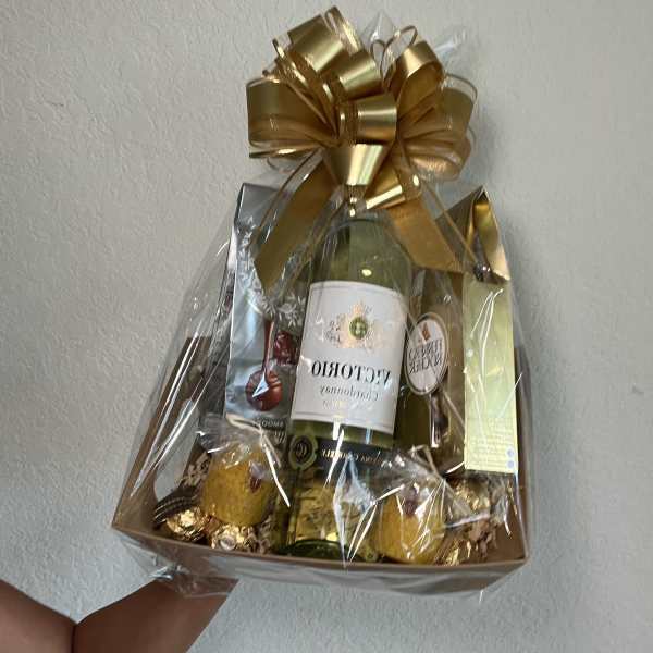 Gift basket with wine bottles, chocolates, and a gold bow