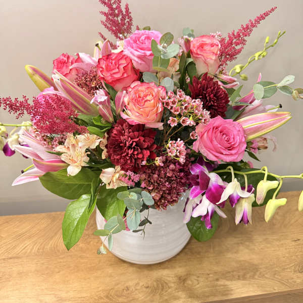 Pink and burgundy mixed bouquet in a white vase