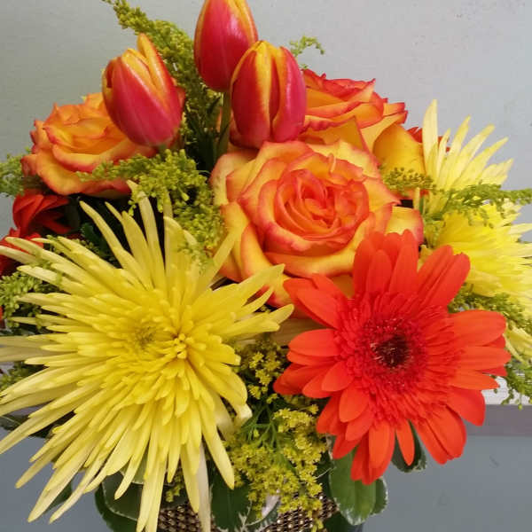 Bright mixed flower arrangement with roses, tulips, gerbera daisies, and chrysanthemums in a vase