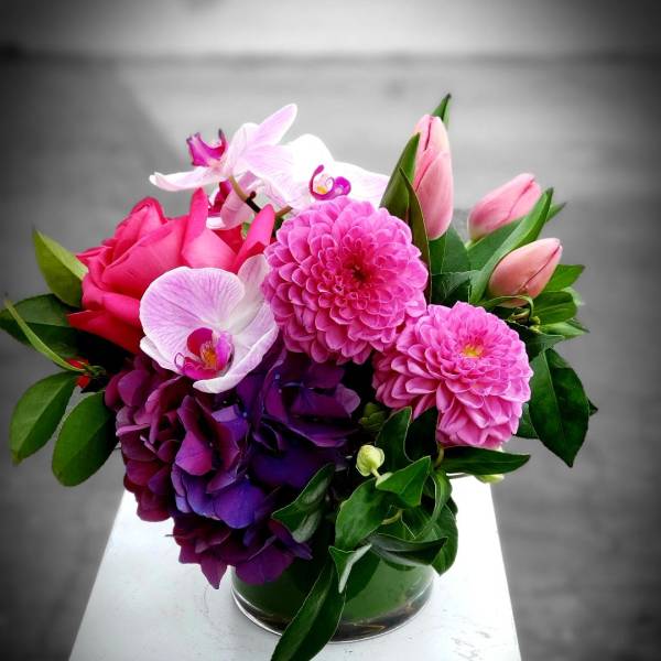 Pink and purple floral arrangement in a glass vase