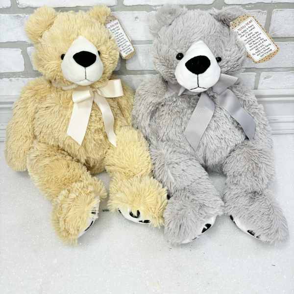 Two plush teddy bears with ribbon bows, one yellow and one gray