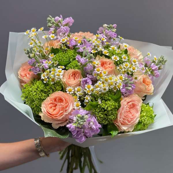 Bouquet of peach roses, purple flowers, and white daisies
