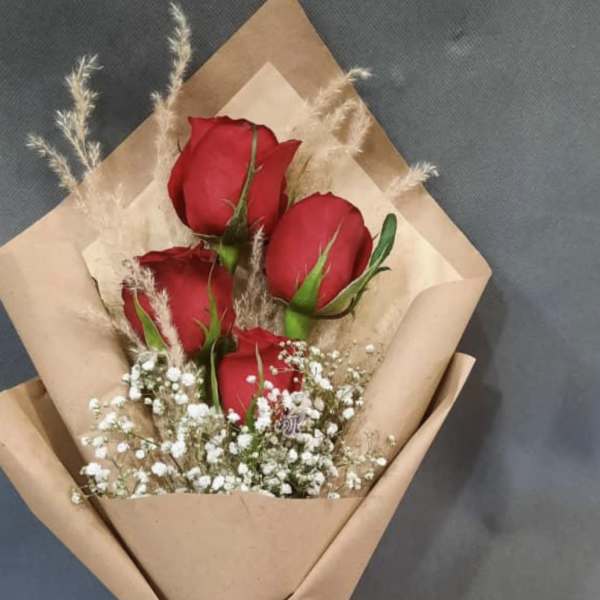 Bouquet of red roses wrapped in brown paper with a red ribbon