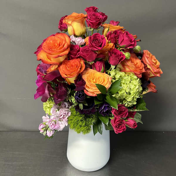 Bright mixed bouquet of roses and hydrangeas in a white vase