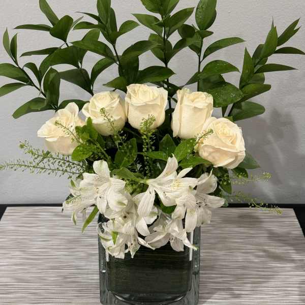 White roses and alstroemeria in a square glass vase